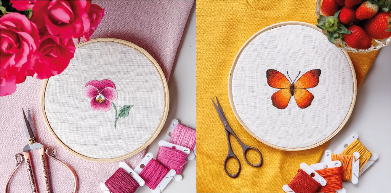 Dois bordados de flores e borboleta, com linhas e tesoura, rosas no fundo.
