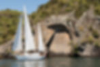 Sailing yacht in front of the Māori Rock Carvings at Mine Bay, Lake Taupō, New Zealand