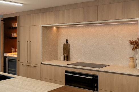 Modern kitchen cabinets with oven, stovetop, cutting board, and INSPACE CABINETRY IN HAUS.