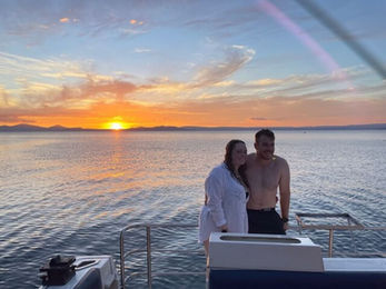 Couple enjoying sunset on Kakariki Catamaran