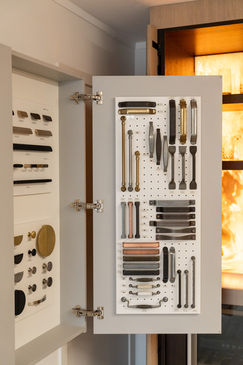 Cabinet door with display of various cabinet hardware samples. INSPACE CABINETRY