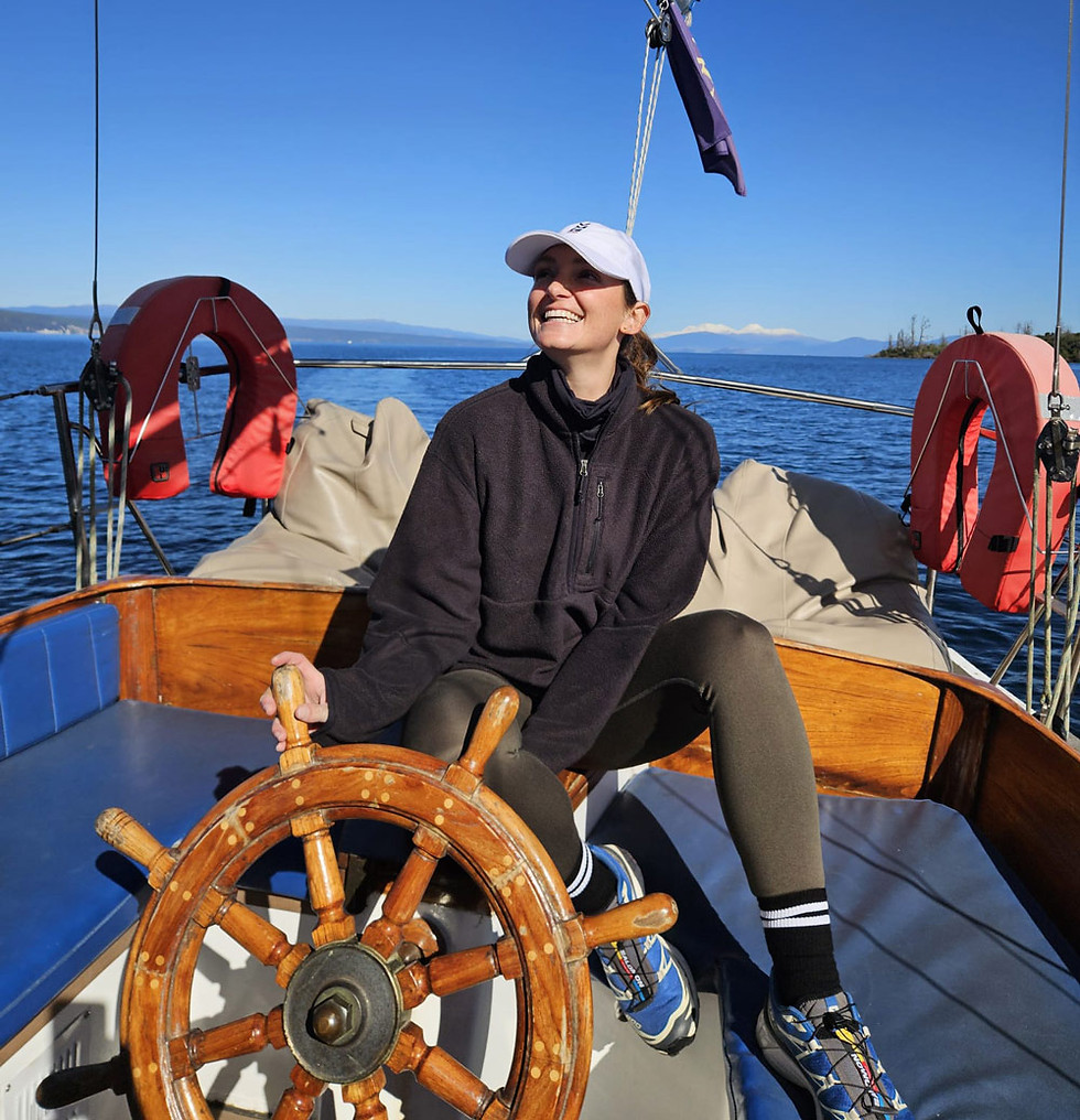 Woman at a wooden Sail Barbary boat cruise wheel on a sunny day