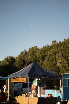 Outdoor market tent with text and a view of the moon and trees.