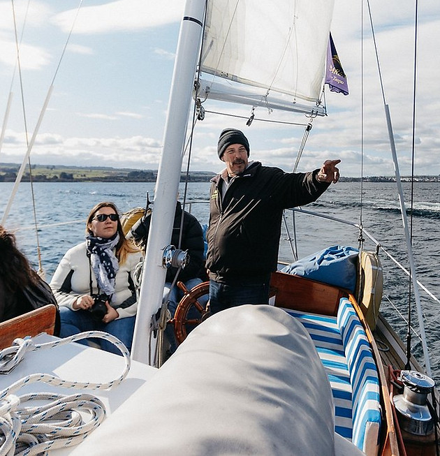 Man pointing from the Sail Barbary showing guests sights and hidden bays