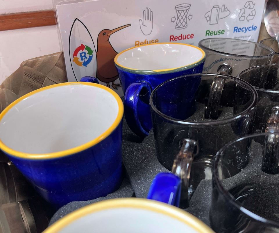 Reusable blue and yellow mugs onboard Sail Barbary, promoting waste minimisation.
