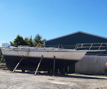 White sailboat on stands needs restoration