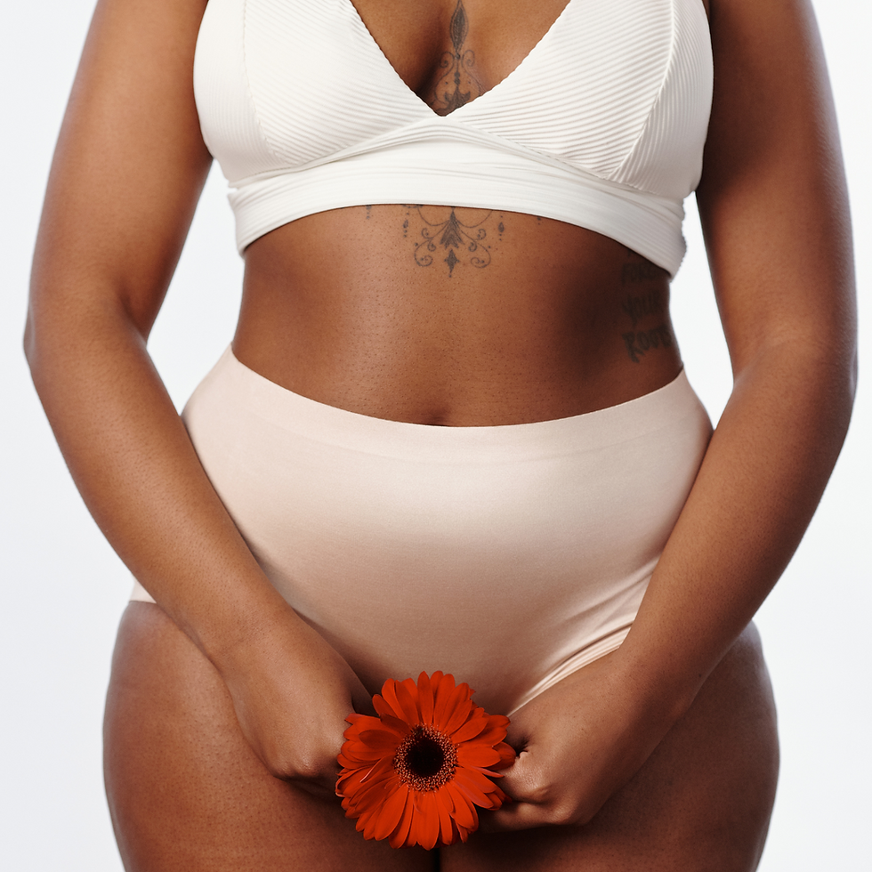 woman holding flower over intimate areas