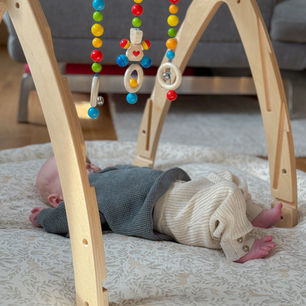 Baby spielt mit Spielebogen