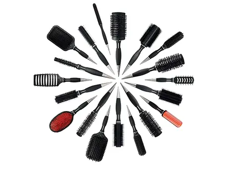 A collection of different hairbrushes laid out in a salon setting, showing options for curly, straight, thick, and afro hair types.