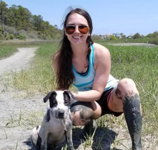 Woman and young pitbull mix puppy at the beach