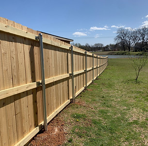 Clean-lined cedar fence with flat top pickets and metal posts, blending strength with natural warmth
