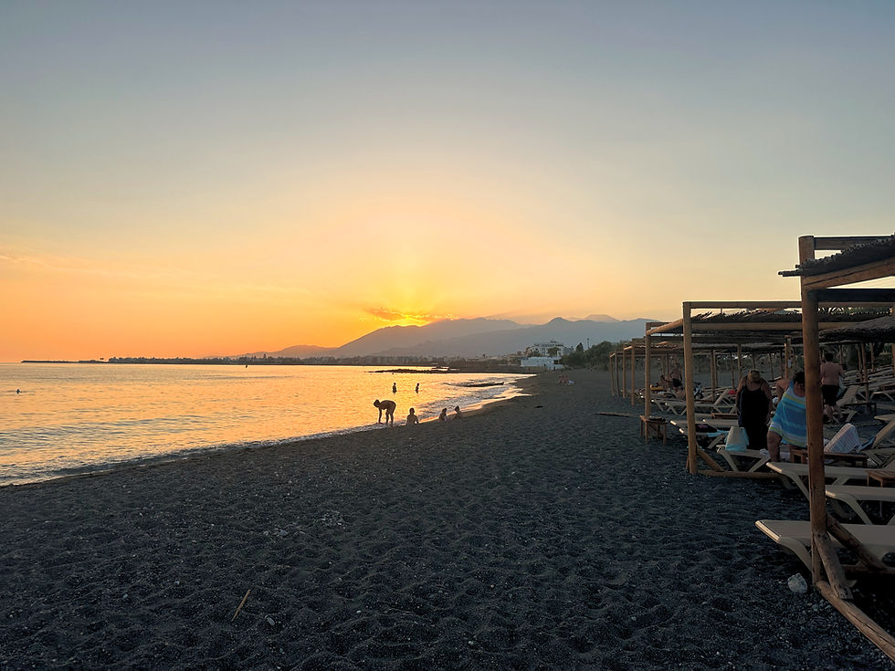 Cinematic sunset over the Libyan Sea near Villa Komorebi, showcasing the 7-minute walk coastal access and mountain views.