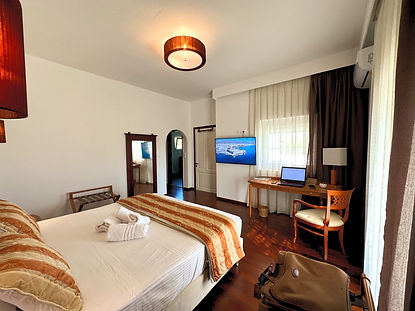 High-speed executive workspace in the Master Suite at Villa Komorebi, featuring an ergonomic chair, large desk, and 50-inch Smart TV for "Cinema in Bed" relaxation.