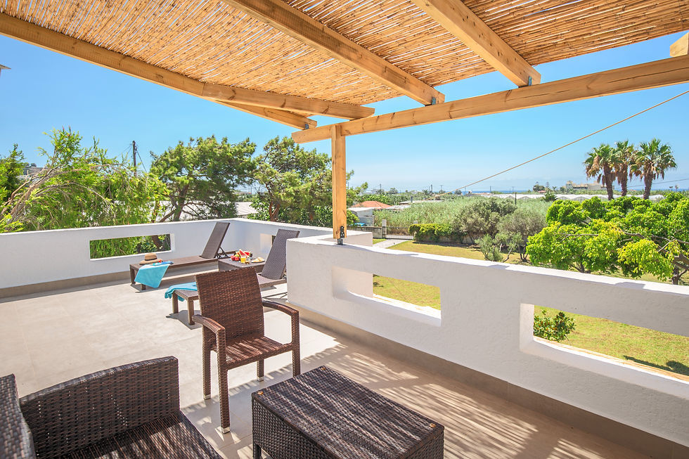 Wide-angle Hero shot of the 60sqm Day & Night Lounge at Villa Komorebi, featuring a massive communal terrace with views of the Libyan Sea and lush olive groves.