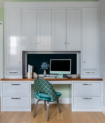 NYC interior designer home office with custom high gloss lacquered built-in desk, storage cabinetry, and velvet accent chair.
