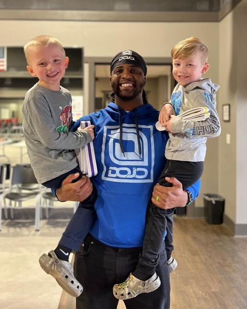 Karate coach holding kids and smiling