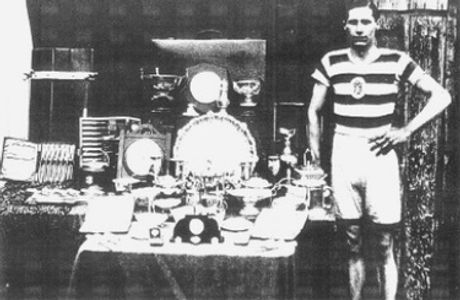 Historic image of a Queens Park Harrier (circa 1900) beside a table of trophies