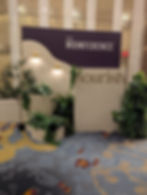 Momference Conference backdrop with waved and straight backdrop layered with wood cut text