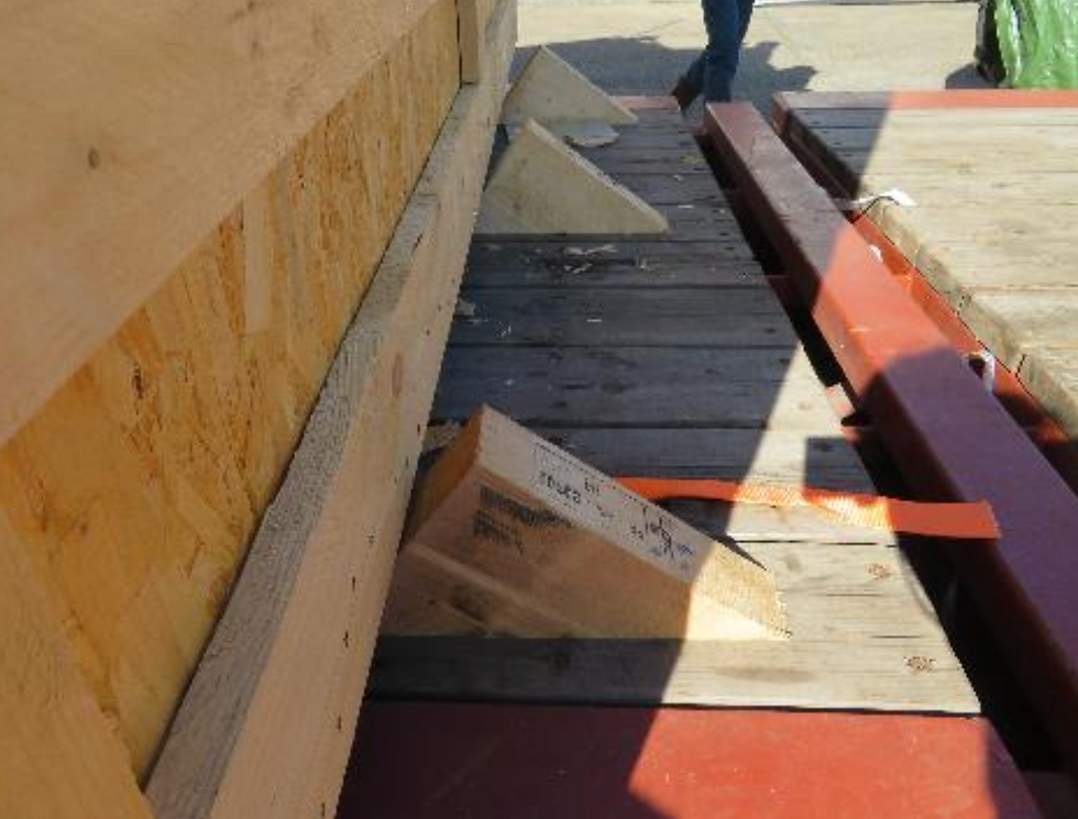 Non-conformité: Charges de plusieurs tonnes sécurisée avec 3 cales clouées sur un conteneur flat-rack