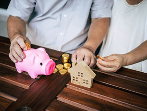 Ein altes Ehepaar unterhält sich über Finanzen – mit Sparschwein