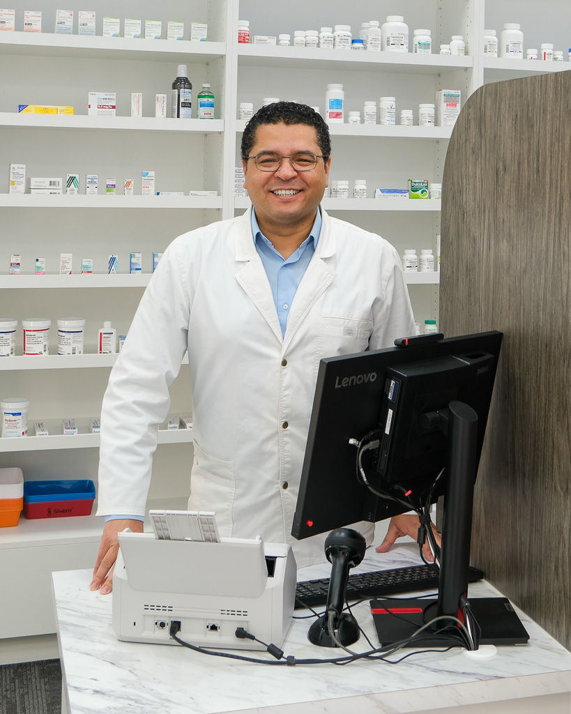 Friendly pharmacist standing behind a pharmacy counter