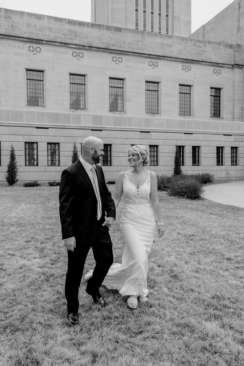 Elegant courthouse wedding in Nebraska – bride and groom share a joyful moment walking hand-in-hand