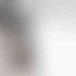 Family of three smiling on a rooftop in downtown Lincoln, Nebraska during golden hour; Candid photo of parents holding child with Lincoln city skyline in the background