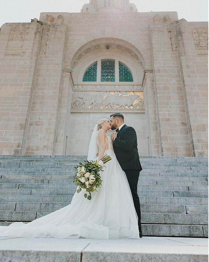 Elegant courthouse wedding in Nebraska – bride and groom share a joyful moment walking han