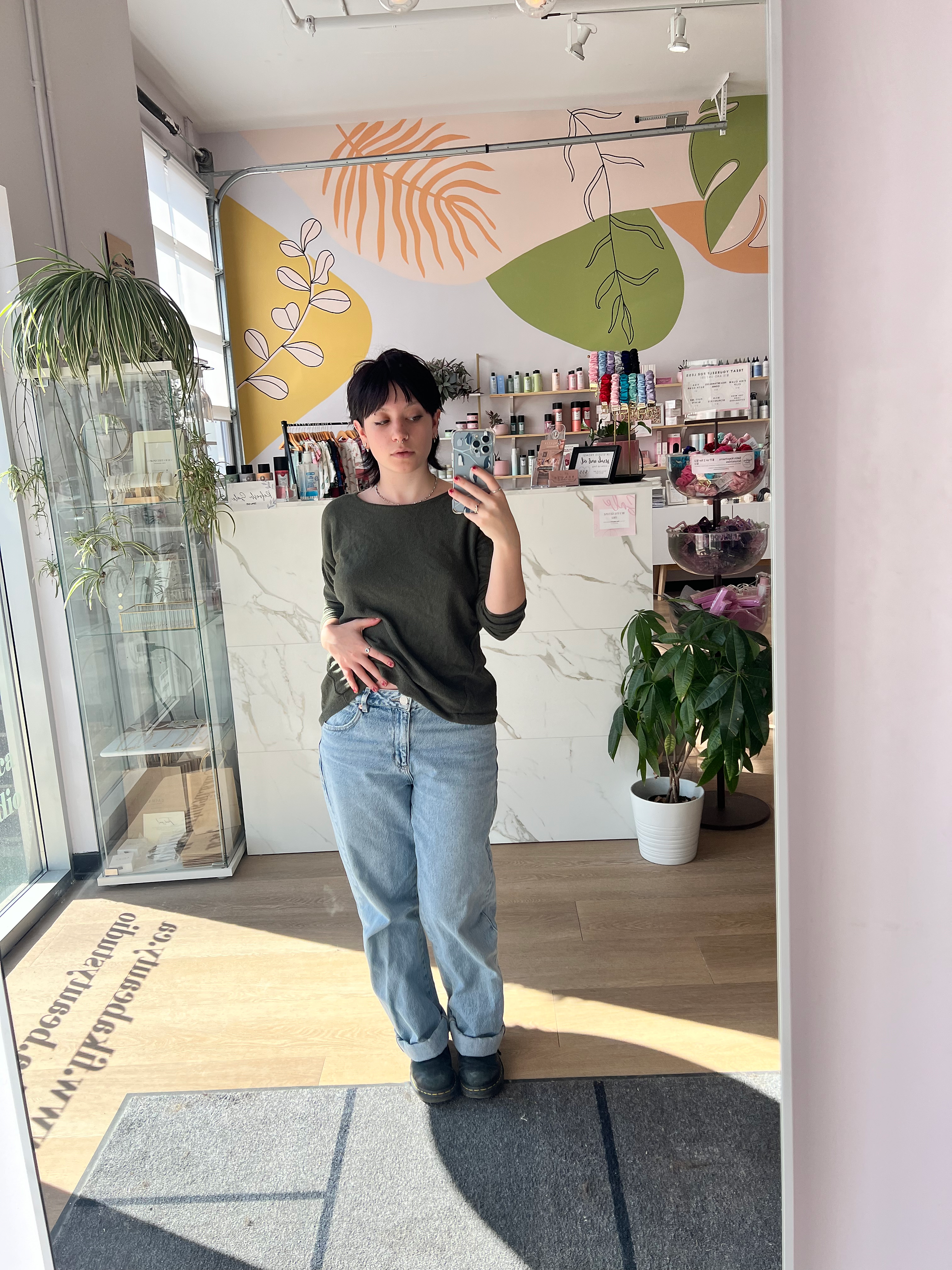 Rachel taking a selfie in jeans and a green longsleeve