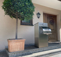 Briefkasten mit Paketbox (Paketbriefkasten) vor dem Haus mit offener Paketbox