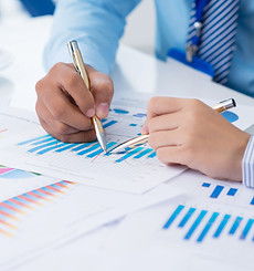 cropped-image-of-businesspeople-analyzing-financial-graphs-on-the-foreground-SBI-325537198