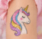 Buntes Einhorn als Print-Tattoo in deinem Design auf einer Kinder-Hand.