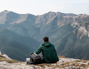 Burnout-Prävention von Diplom- & Sozialberaterin Karin Jungmair von Sinnvollleben: Eine Person sitzt auf einem Berggipfel und gewinnt durch Ruhe, Weitblick und Achtsamkeit neue Energie und innere Stärke.