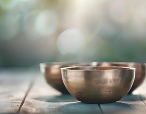 Vier Klangschalen auf Holztisch. Dieses Bild symbolisiert die Klangmassagen und Klangreisen im Angebot von Diplom- & Sozialberaterin Karin Jungmair von Sinnvollleben – zur Tiefenentspannung, inneren Balance und bewussten Auszeit vom Alltag.