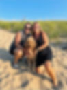 Picture of Lori, Bob her husband and their dog, Teddy at the beach.