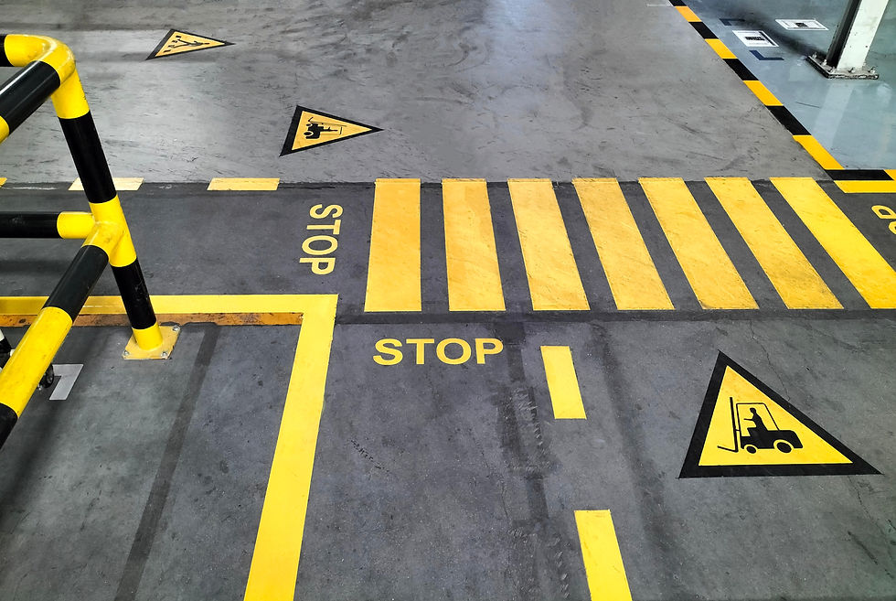 Industrial building corridor painted yellow between parallel yellow lines on abstract ceme