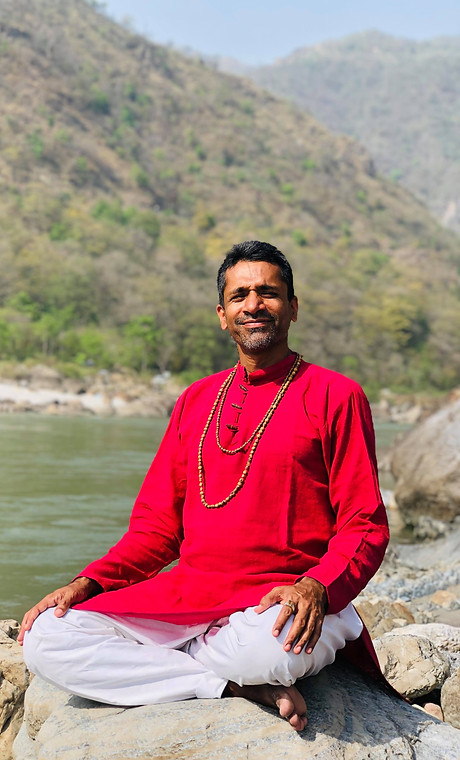 Swami looking at camera in red kurta at