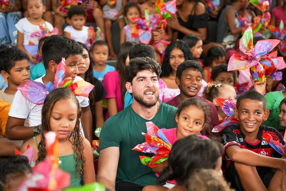 Davi Brandão rodeado de crianças durante a Rota da Páscoa após a entrega de ovos de chocolate