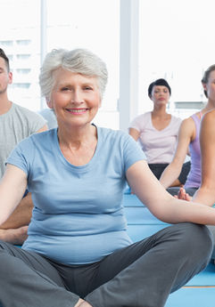  A group of individuals, mostly women, practicing meditation in a calm indoor environment, focusing on mindfulness.