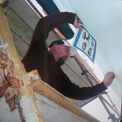 Kevin Hasson painting 'John Hume' mural