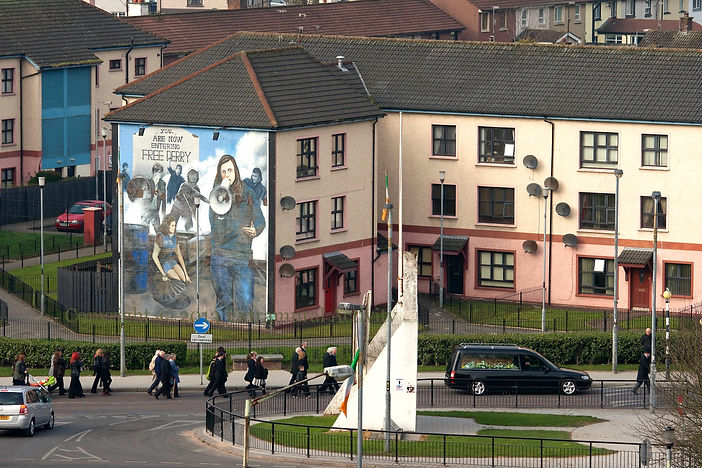 A Derry funeral procession passes 'Bernadette' - The Bogside Artists