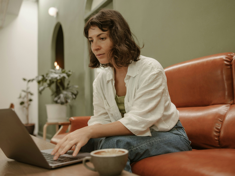 A woman leaning over a laptop. Psychotherapy in the Digital Age.