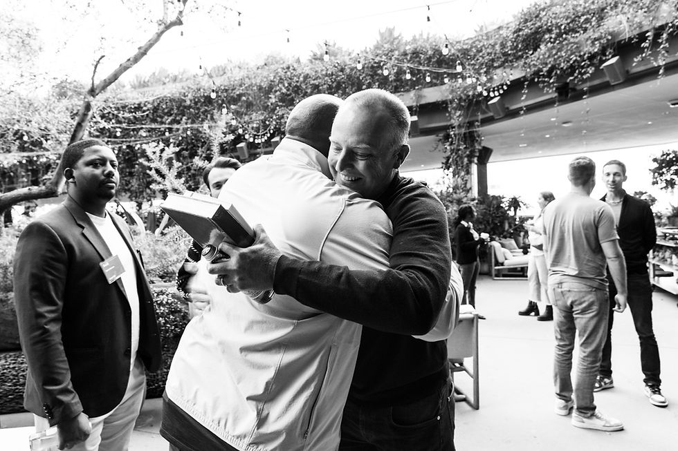 Clarence hugging business partner