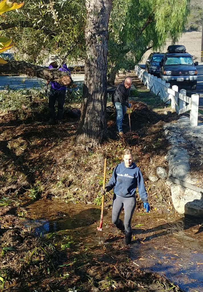 Canyon Club Members cleaning up along the canyon/stream with gloves, shovels, rakes