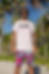Man in CAN t-shirt and swim trunks, palm trees in the background