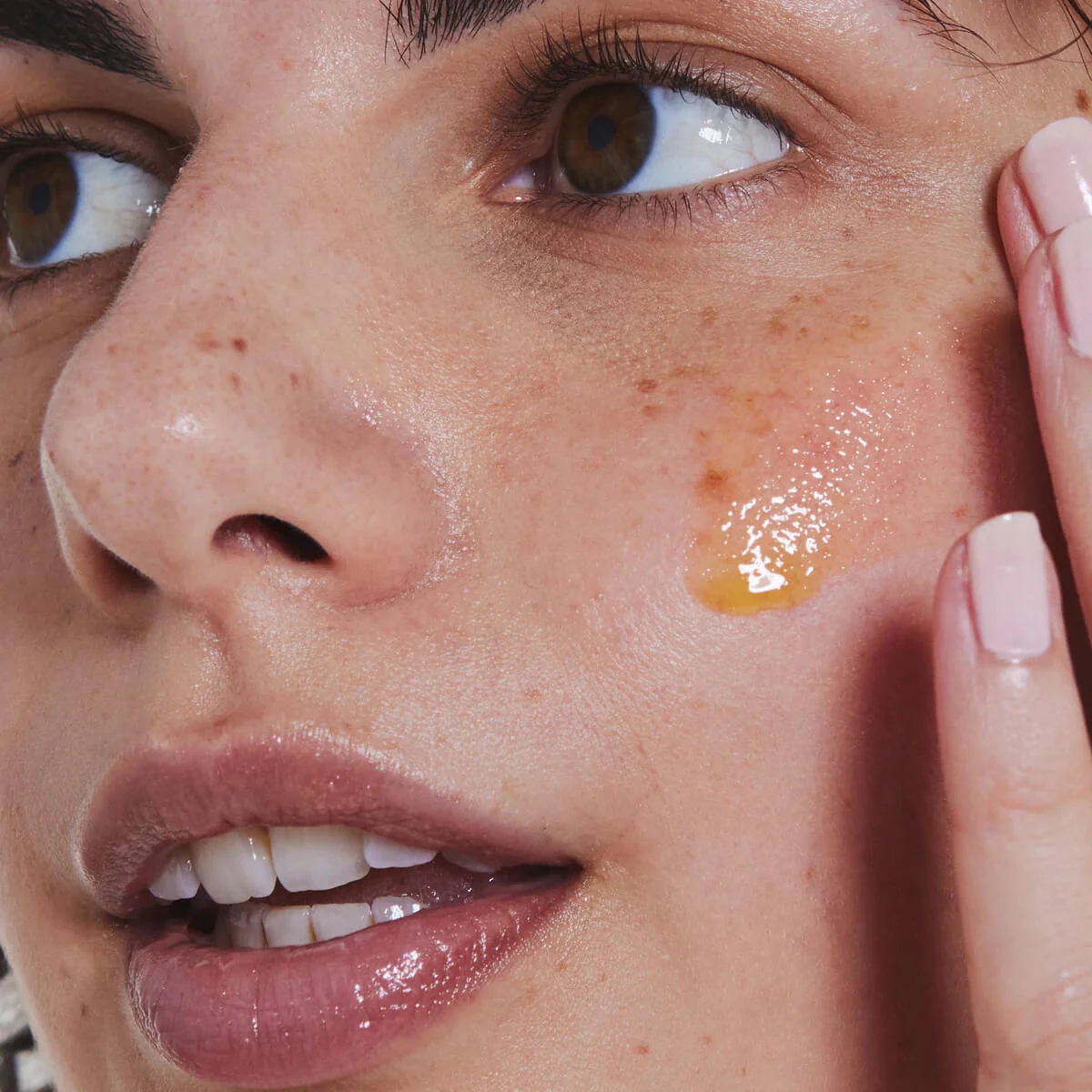 Woman putting serum on her face