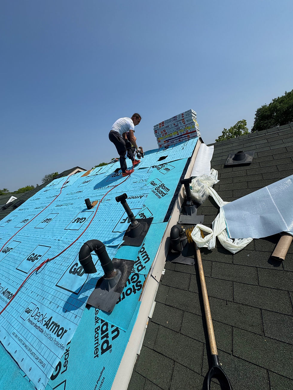A roofing crew installing underlayment on a residential roof in the Greater Toronto Area, preparing the surface for new asphalt shingles.