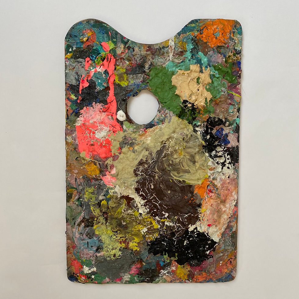 Vintage artist's palette with a thick melange of variously brightly-coloured paints