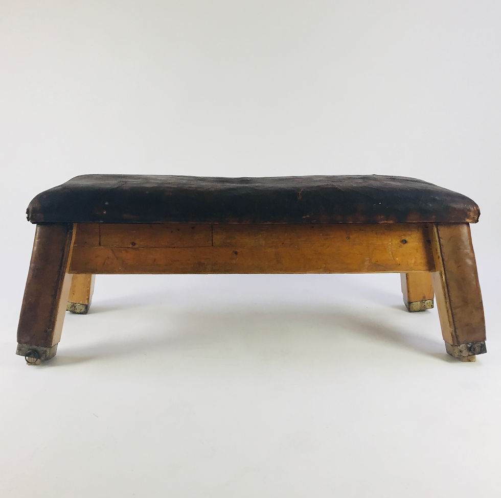 Vintage gym bench with heavily worn dark brown leather top