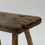 Thumbnail: A primitive wooden stool with four splayed legs